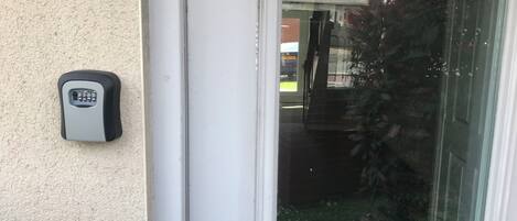 A door with a keypad lock and a glass door.