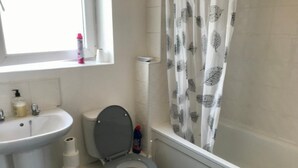 A bathroom with a toilet, sink, and shower curtain.