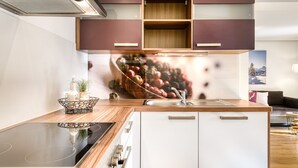 Eine moderne Küche mit integriertem Herd, Holzschränken und einem großen Fenster über der Spüle.