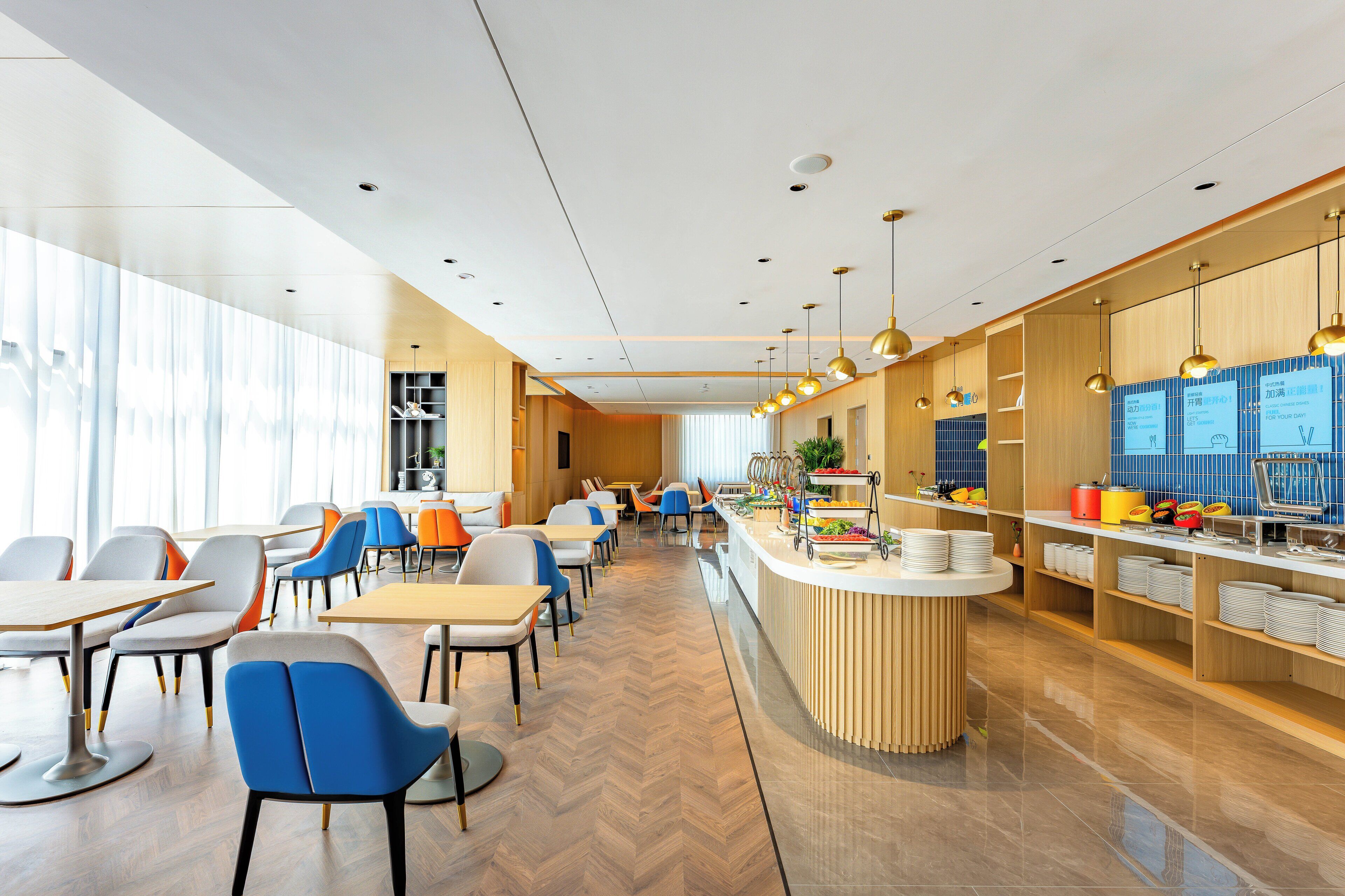 Een moderne eetruimte met een centraal eiland, diverse zithoeken en een buffetopstelling.