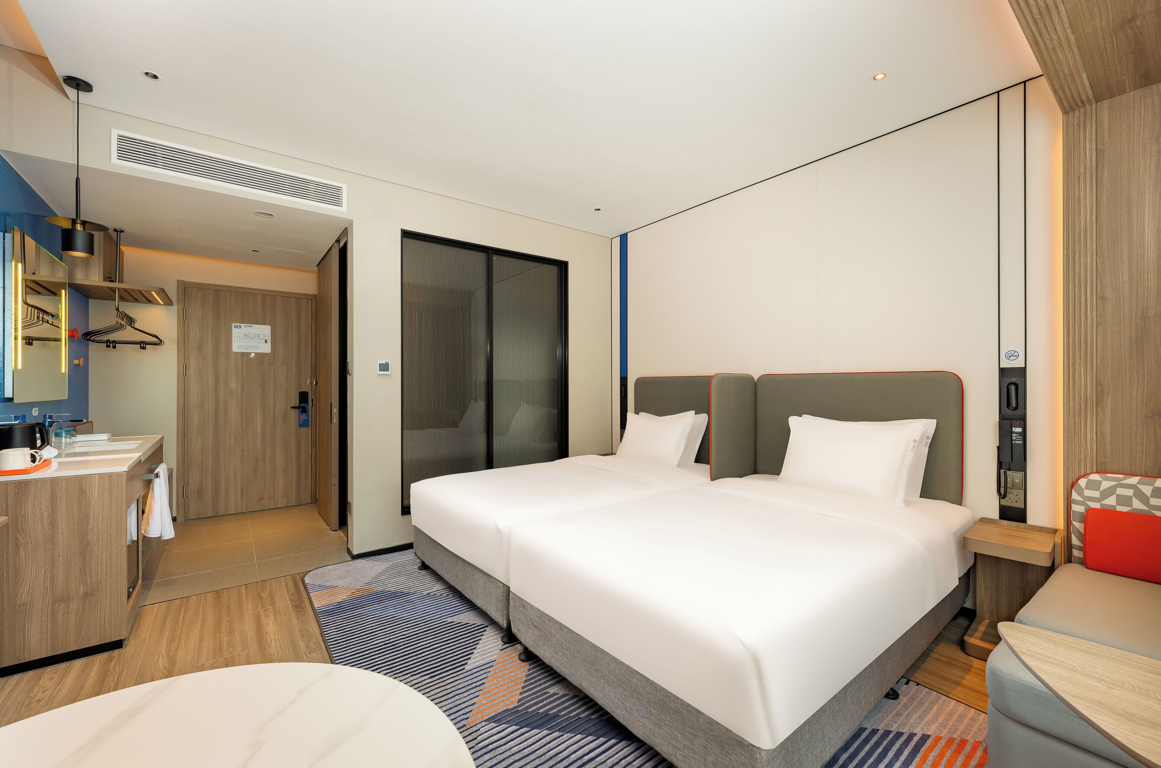 Una habitación de hotel moderna con una cama grande, un escritorio y un baño.