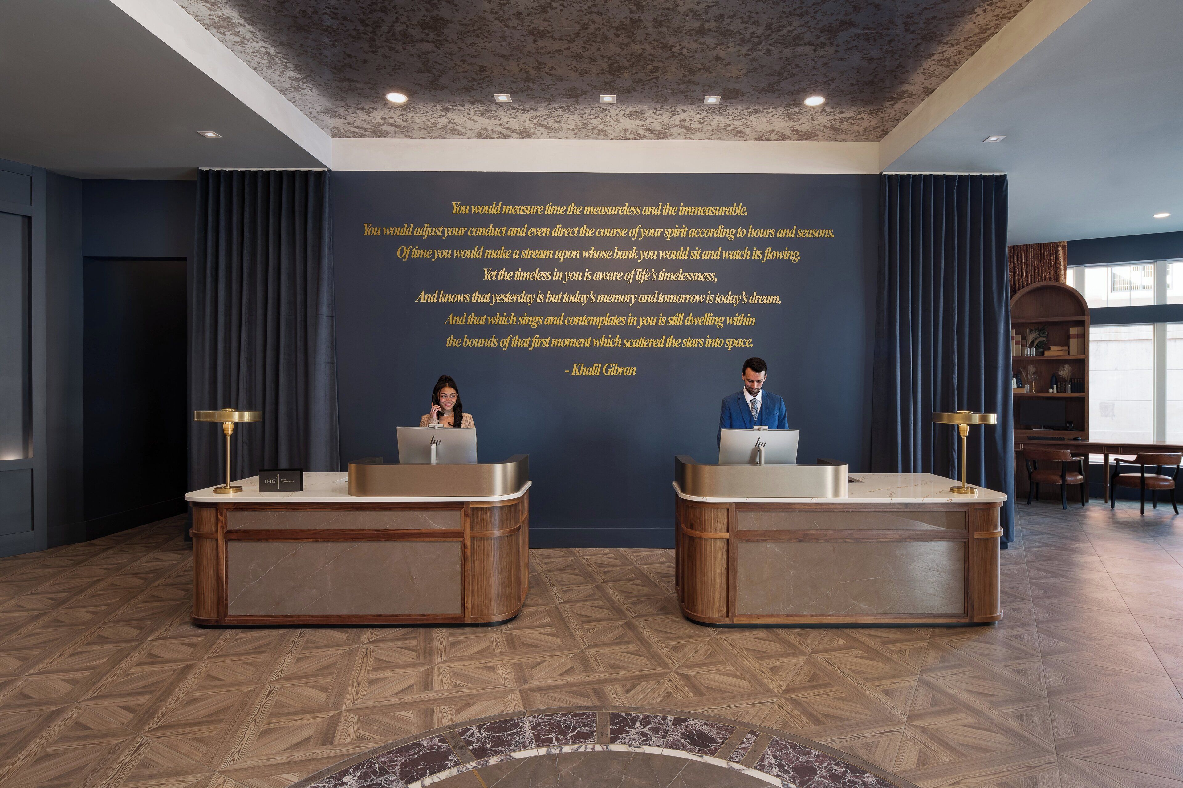 A reception area with two reception desks, a quote on the wall, and a patterned floor.