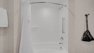 A modern bathroom with a shower, a towel rack, and a hanging bag.
