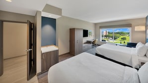A hotel room with two beds, a desk, a TV, and a window with a view of a park. - Holiday Inn Express & Suites Fort Walton Beach Eglin Area by IHG (Fort Walton Beach)