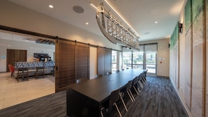 A conference room with a long table, chairs, and a modern ceiling design. - Holiday Inn Express & Suites Fort Walton Beach Eglin Area by IHG (Fort Walton Beach)