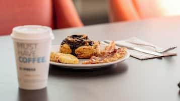 A table with a coffee cup and a plate of food.
