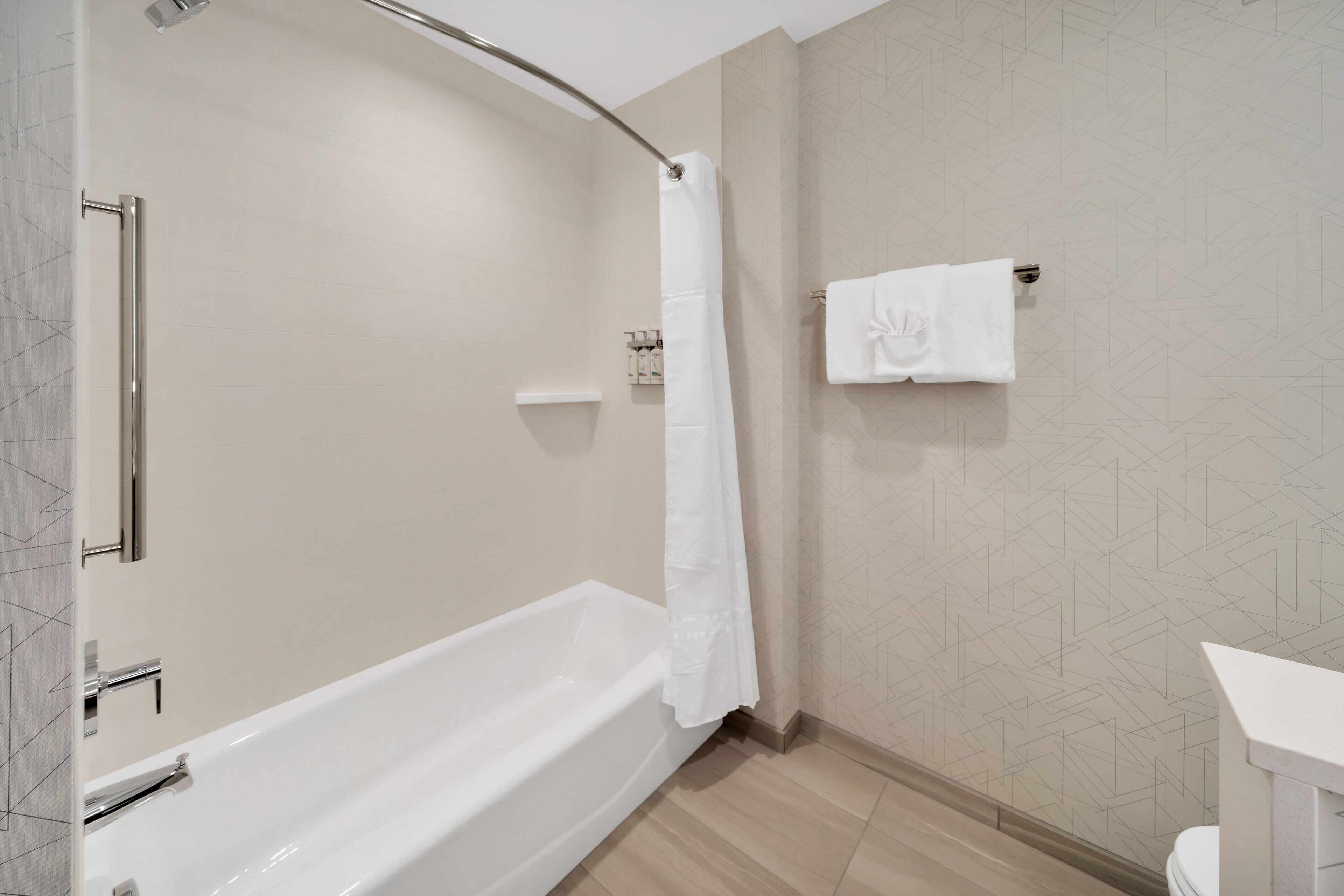 Un baño moderno con bañera, cortina de ducha y barra para toallas.