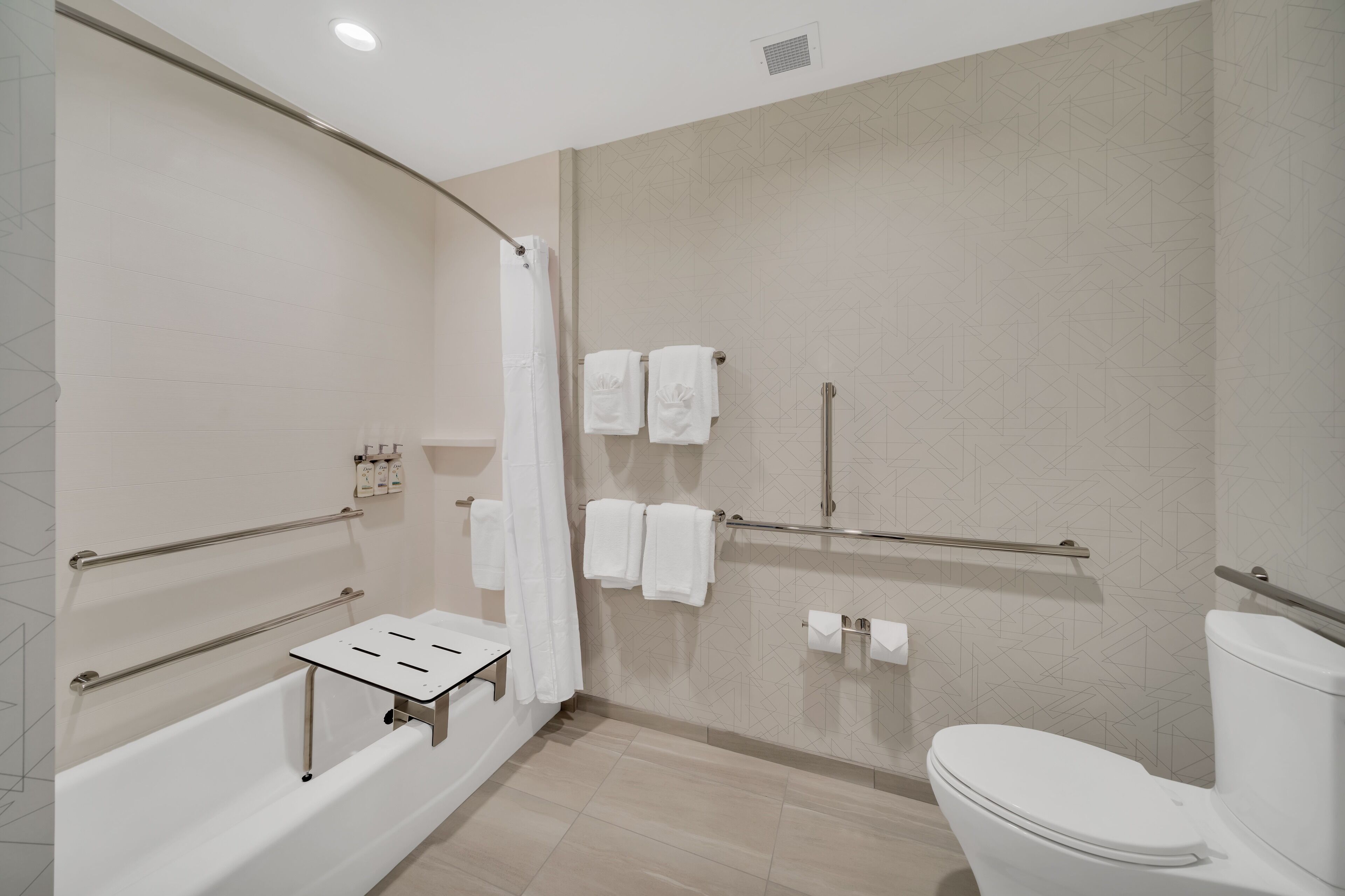 A modern bathroom with a bathtub, shower, and toilet.