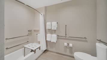 A modern bathroom with a bathtub, shower, and toilet.