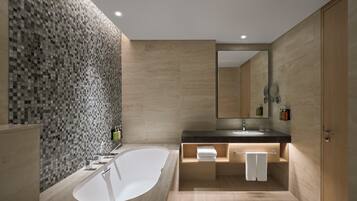 A modern bathroom with a large bathtub, a sink, and a mirror.