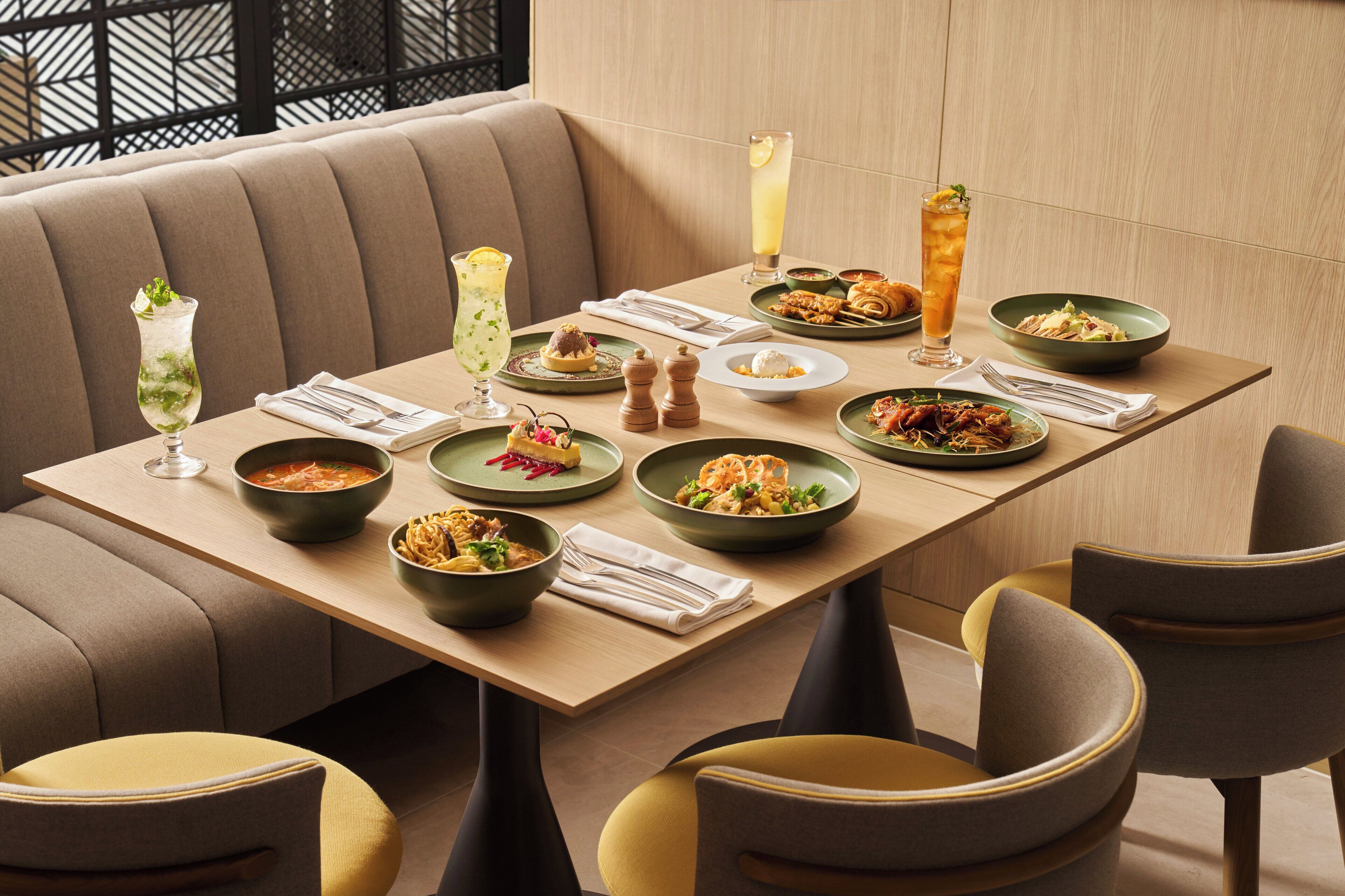 A dining area with a long table set for a meal, surrounded by chairs.