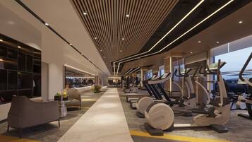 A modern gym with cardio equipment, a central walking path, and a seating area with a plant.