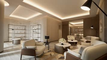 A modern living room with a sofa, armchairs, a coffee table, and a bookshelf.
