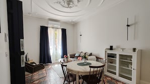 A dining area with a round table, chairs, and a cabinet with shelves. - Appartement Dans Maison de Maître au Cœur des Corbières, à 9 min de Fontfroide (Saint-André-de-Roquelongue)