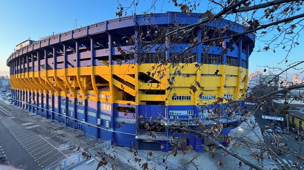 A multi-story building with a distinctive yellow and blue color scheme, featuring a series of balconies and a central open space. - Howard Johnson Undici Republica de La Boca (Buenos Aires)