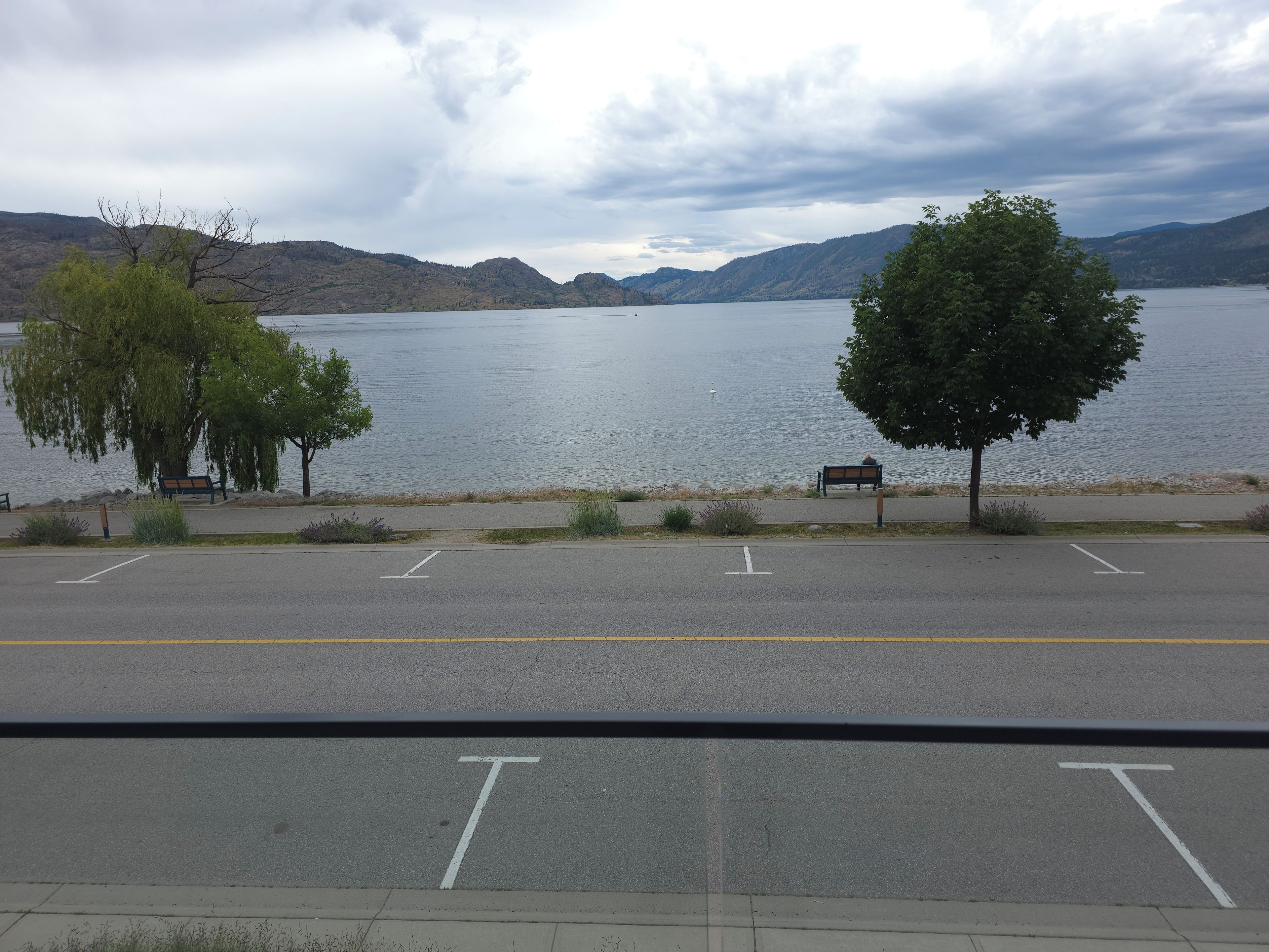 A parking lot with a view of a lake and mountains.