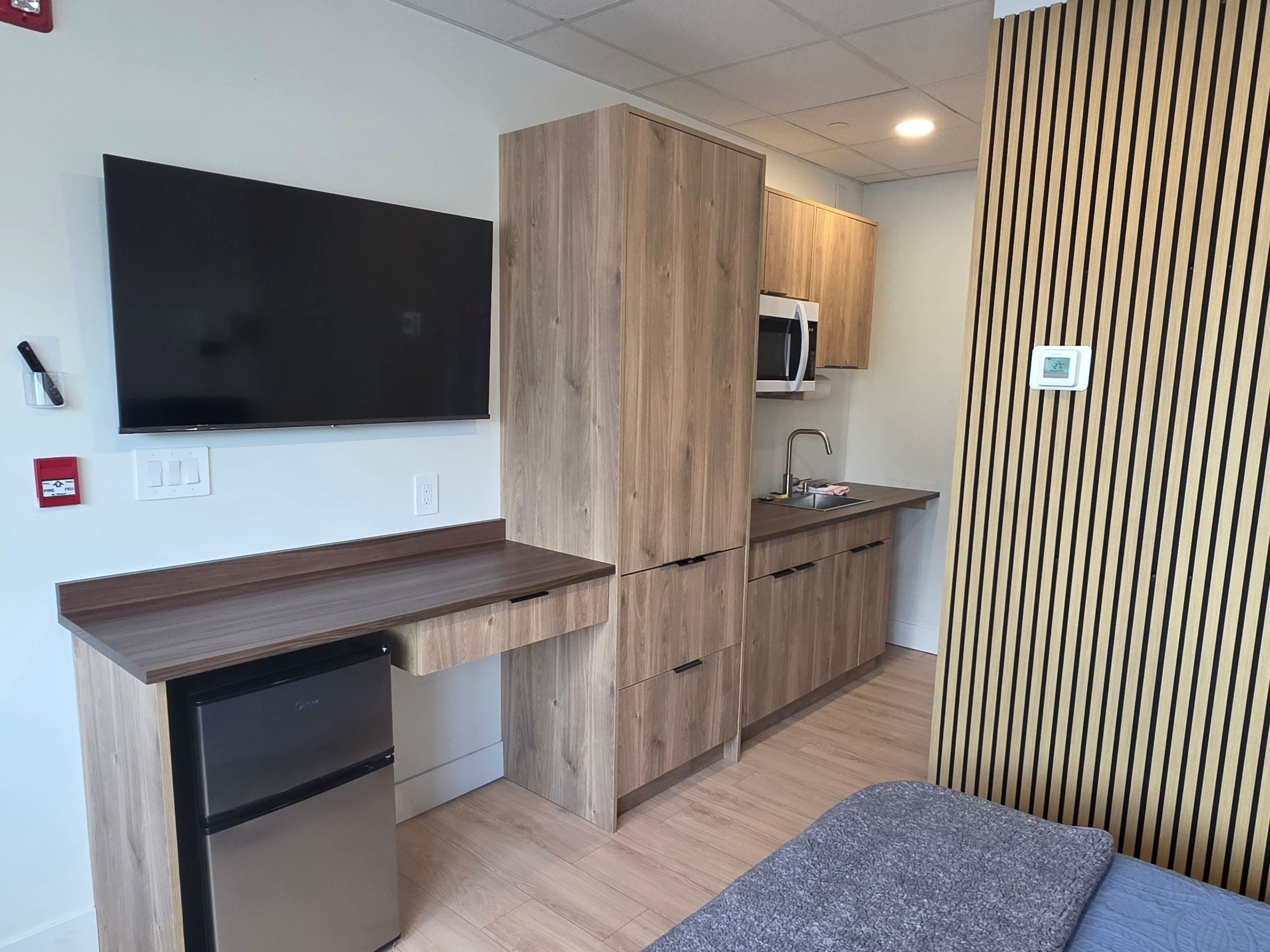 A compact kitchenette with a built-in microwave, a sink, and a small refrigerator.