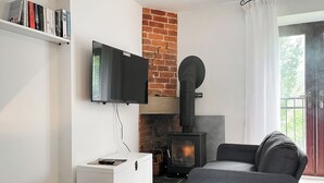 A living room with a fireplace, a TV mounted on the wall, and a sofa.