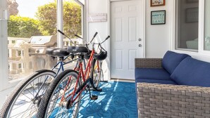 Une pièce avec un sol à motifs bleus, un canapé bleu et deux vélos appuyés contre un mur.