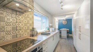 Een moderne keuken met patroon tegels, een inbouwoven en een magnetron.