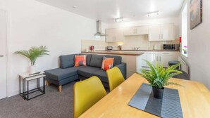 A modern apartment with a living area, dining space, kitchenette, and a small balcony. - Stylish 5 Bed Flat in Thornaby, Ideal for Groups (Thornaby)