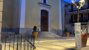 A building with a large wooden door, steps leading up to it, and a signboard in front. - Magnifique 6 Personnes Avec Terasse Tropezienne Refait à Neuf (Bandol)