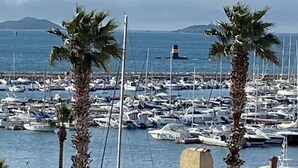 A marina with numerous boats docked, palm trees, and a lighthouse in the background. - Magnifique 6 Personnes Avec Terasse Tropezienne Refait à Neuf (Bandol)