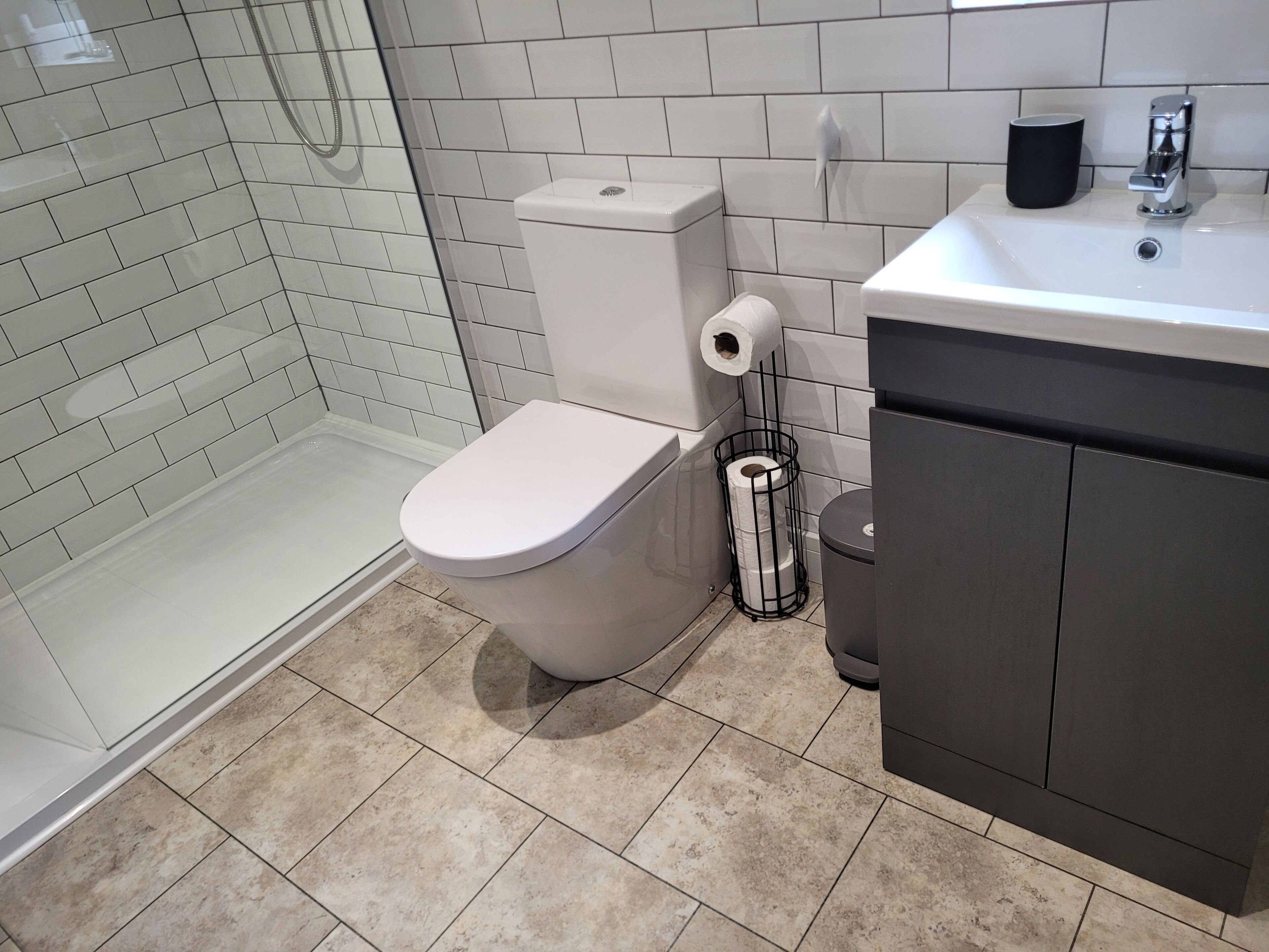 Une salle de bain moderne équipée de toilettes, d’une douche et d’un lavabo.