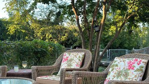 Wicker furniture with floral cushions and a glass table in an outdoor setting. - Cute and Close to Downtown! Off street parking w/ short walk to Academy/Stadium (Annapolis)