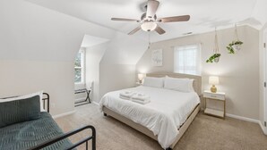 A bedroom with a bed, bedside tables, a ceiling fan, a chair, and a window. - Charming 4BR ★ Family-Friendly ★ w/Backyard ★ (Raleigh)