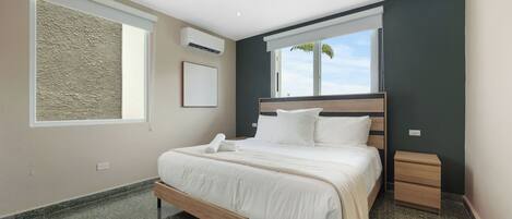 Un dormitorio moderno con una cama de madera, una mesita de noche, un ventanal con vistas y un equipo de aire acondicionado.