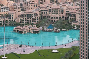 Una piscina grande y central rodeada por edificios de varios pisos con ventanas y balcones arqueados.