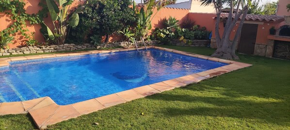 Relax by the serene pool surrounded by lush greenery and beautifully manicured lawn.