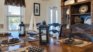 A dining room with a wooden table set for a meal, surrounded by blue chairs, a decorative lantern, and a ship model. - The River House, Pet Friendly with a Hot Tub 15 Minutes to many attractions!! (Shenandoah)