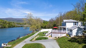 A lakeside property with a white house, a dock, and a clear view of the lake. - The River House, Pet Friendly with a Hot Tub 15 Minutes to many attractions!! (Shenandoah)