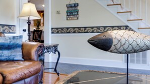 A modern living room with a leather sofa, a glass coffee table, and a decorative fish sculpture. - The River House, Pet Friendly with a Hot Tub 15 Minutes to many attractions!! (Shenandoah)