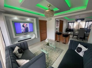 Relax in this stylish living room with a flat-screen TV, comfortable sofas, and a dining area.