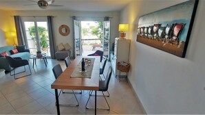 Ein modernes Wohnzimmer mit Essbereich, einer Treppe und einem Balkon mit Blick.