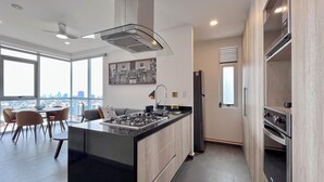 Una cocina moderna con una isla central, electrodomésticos de acero inoxidable y una zona de comedor con vistas.