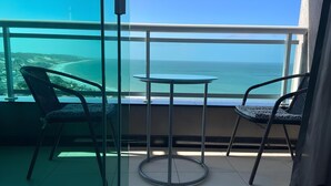 A balcony with two chairs and a small table, overlooking a coastal view. - Duna Barcane Vista Mar Pontanegra Natal (Natal)