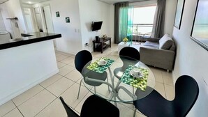 A modern apartment with a kitchen, dining area, and living room. - Duna Barcane Vista Mar Pontanegra Natal (Natal)