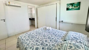 A bedroom with a bed, a wardrobe, an air conditioning unit, and a painting on the wall. - Duna Barcane Vista Mar Pontanegra Natal (Natal)