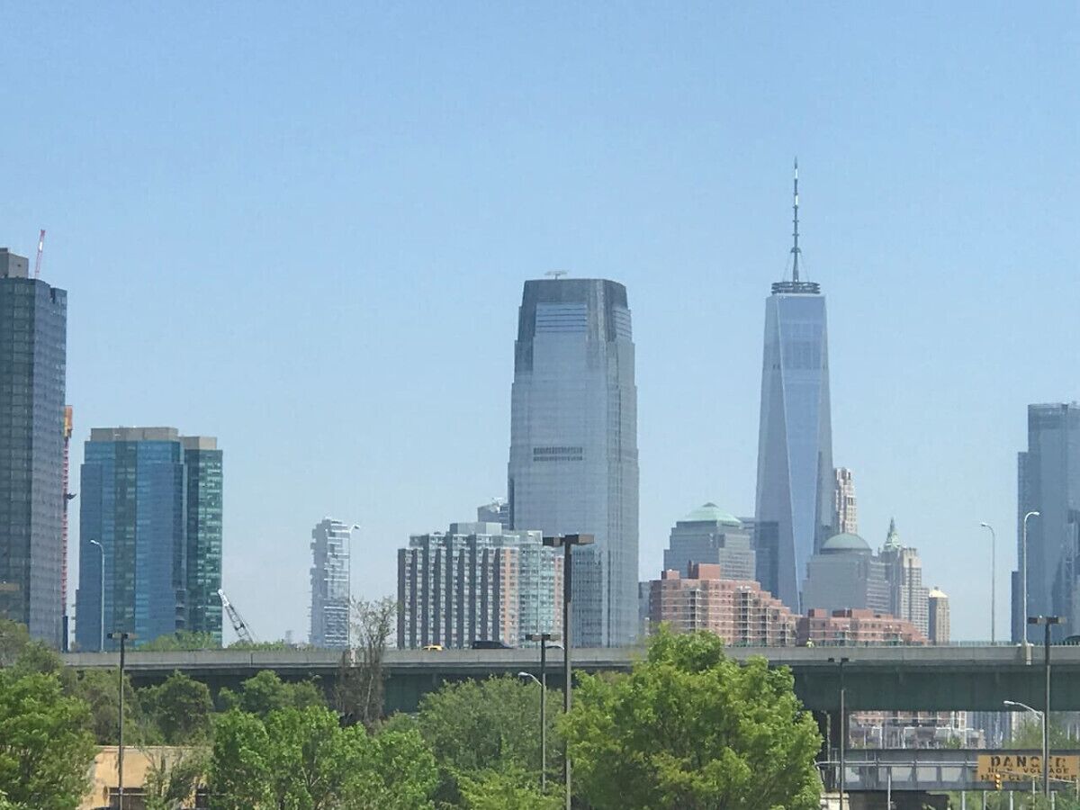 Un horizonte urbano con edificios modernos y altos, incluyendo un rascacielos destacado con una cima puntiaguda.