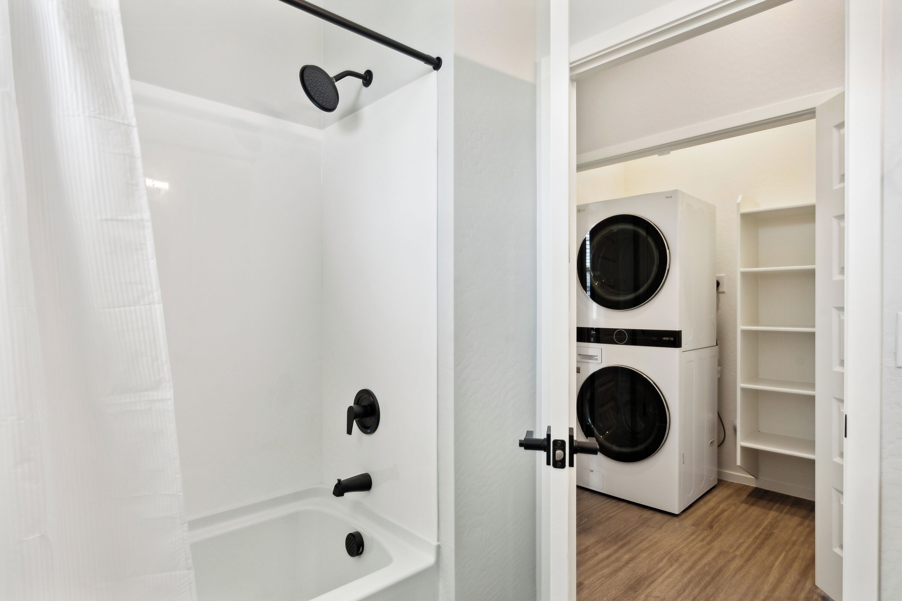 Un baño con bañera, ducha y lavadora secadora integrada.