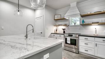 Horno, parrilla de estufa, comedor y isla de cocina