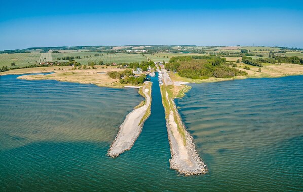 An aerial view of a river with a narrow waterway dividing it. - Apartments Boddenblick (Sagard)
