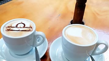 Dos tazas de café con leche y diseños de latte sobre una mesa de madera.