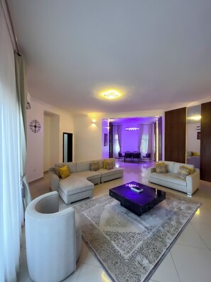 Deluxe Apartment, 3 Bedrooms, Private Bathroom | Living area | 65-inch Smart TV with cable channels