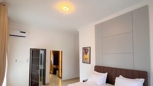 Een hotelkamer met een groot bed, een flatscreen televisie, een kledingkast en een plafondlamp.
