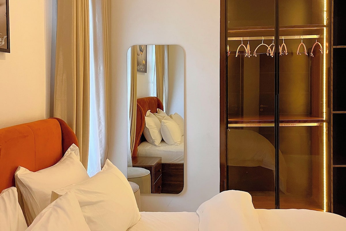 Une chambre d’hôtel équipée d’un lit, d’une armoire, d’un miroir et d’un porte-manteau.